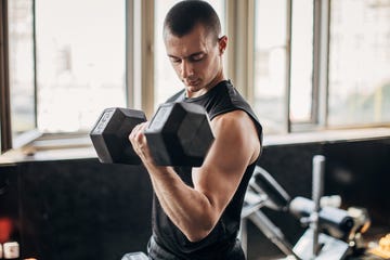 man exercising with dumbbell in gym