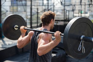 man lifting barbell exercising at rooftop gym