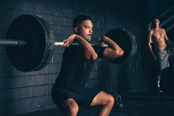 man lifting barbell in gym