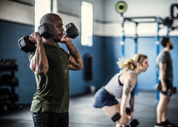 man lifting dumbells at cross training gym