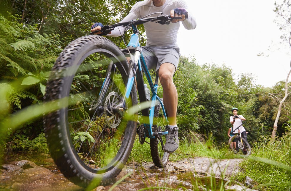 Man mountain biking on muddy trail