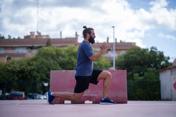 man trains his legs with power lunges in a park outdoors