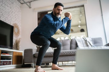 mature man doing online exercise class at home