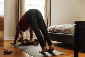 mature man practicing yoga in bedroom