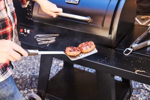 brad ford grilling burgers on a smoker