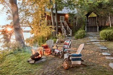 rustic fire pit with adirondack chairs at lake cabin