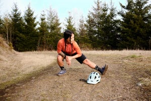 mountain biker stretching to avoid leg cramps