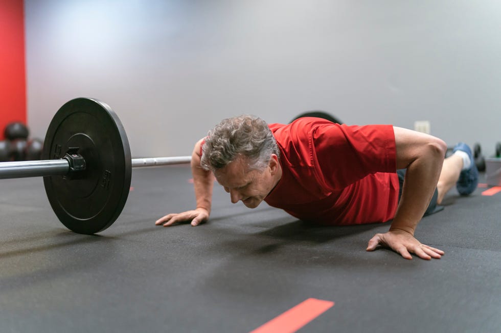 middle aged man doing workout at gym