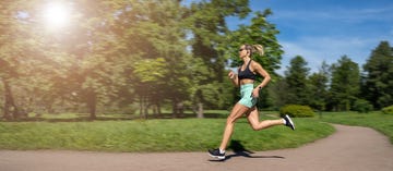 middle aged slim caucasian woman sportswear running,jogging training in park in sunny day summer,russia
