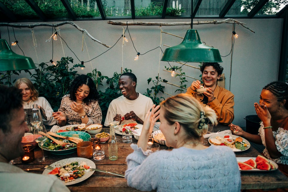 friends having dinner together laughing