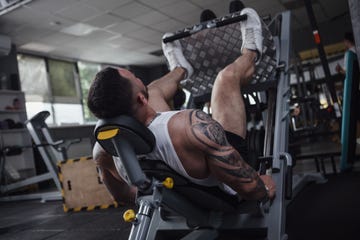 muscular male bodybuilder working out at gym