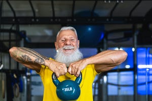 senior fitness man doing kettle bell exercises inside gym   fit mature male training in wellness club center   body building and sport healthy lifestyle concept