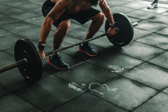 a man doing a push up on a barbell