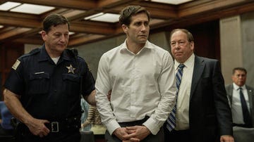 a police officer taking a lawyer into custody as his colleagues watch