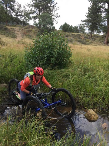 quinn brett on her adaptive cycle crossing a river