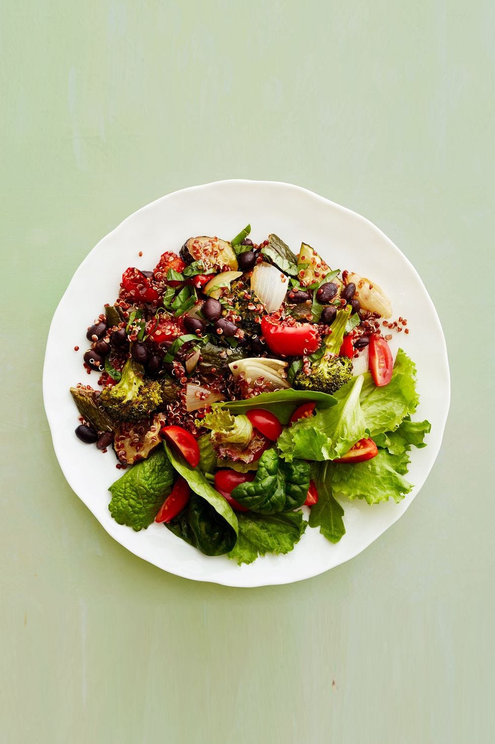 quinoa and veggies with a side salad on a white plate