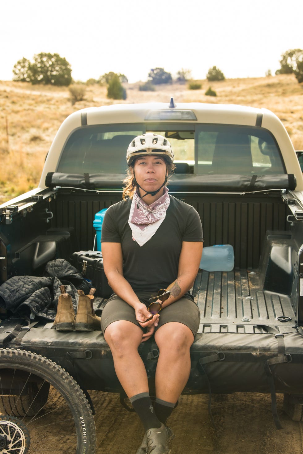 rachel olzer sitting in back of truck wearing a helmet and bandana