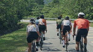 rear view asian chinese cyclist leader leading team cycling in rural area during weekend morning