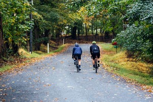 two cyclists riding together up a hill