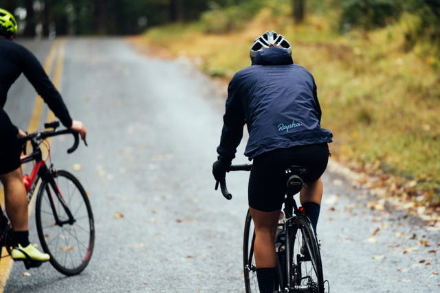 a person riding a bicycle on a road on a grey day