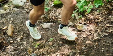 a person's legs and feet in the dirt