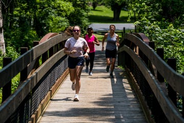 a group of people running on a bridge