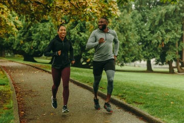 two runners on a paved path through a park