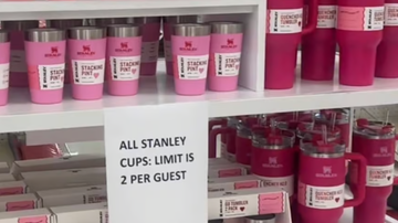 a shelf with a sign and containers of red liquid on it