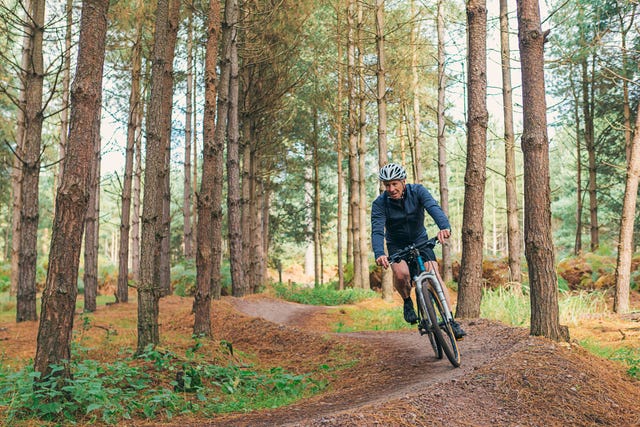 senior male on bike trail in forest