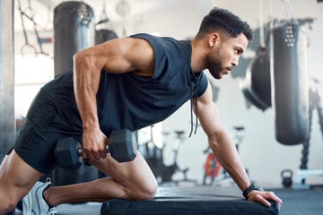 shot of a sporty young man exercising with a dumbbell in a gym