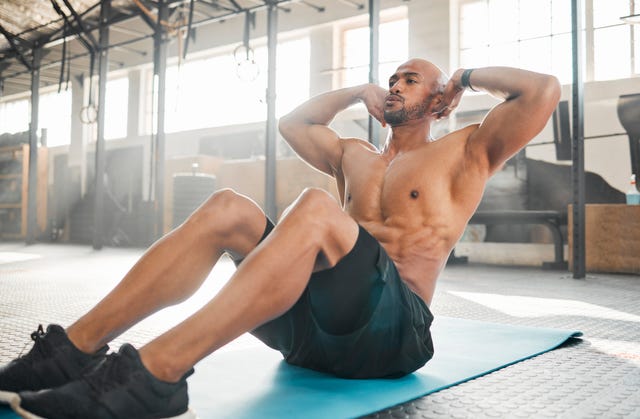 shot of a young man completing crunches