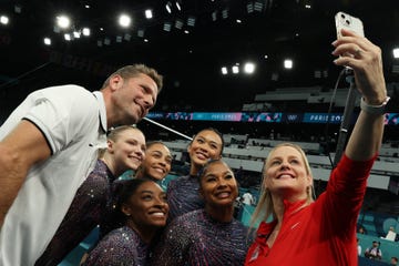 laurent landi, jade carey, simone biles, hezly rivera, suni lee, jordan chiles, and cecile landi pose for a selfie