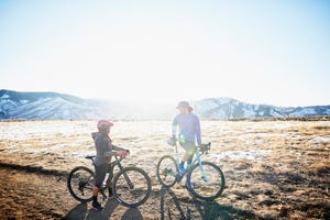 smiling friends in discussion during gravel bike ride on winter afternoon