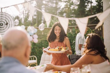 smiling girl serving food in party at backyard mother's day activities