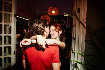 smiling woman embracing boyfriend during party in night club