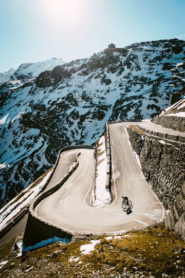 a cyclist descending switchbacks on a mountain road