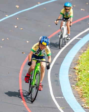 two young kids riding bikes on velodrome