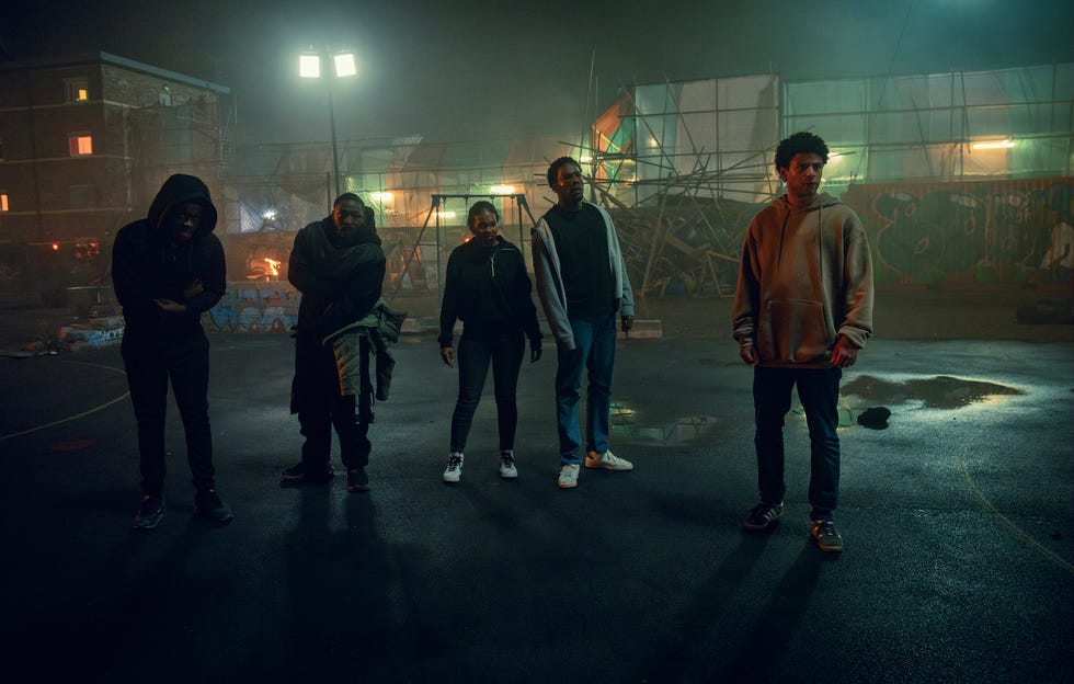 a group of people walking on a street at night