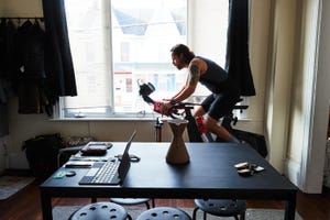 a man rides an stationary bike in front of a large window