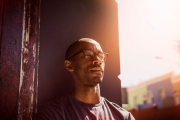 thoughtful man leaning on wall in city