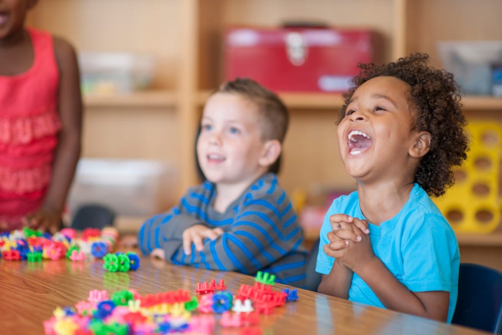 two kids laughing at table in classroom