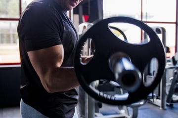 hombre entrenando los brazos con barra