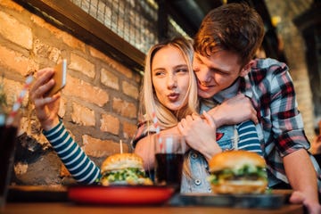 young couple making a selfie while having lunch at the pub