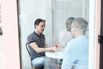 view through window at three men in a cafe drinking wine