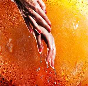 woman's wet hands against orange background