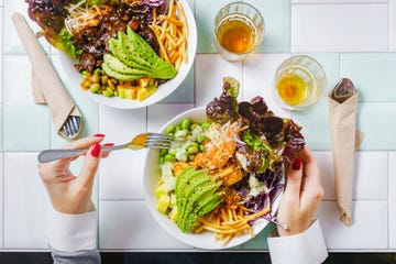 woman eating a vegan salad bowl for lunch at the restaurant