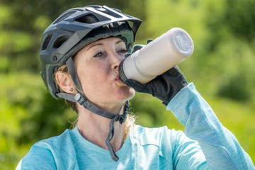 woman in helmet drinking water