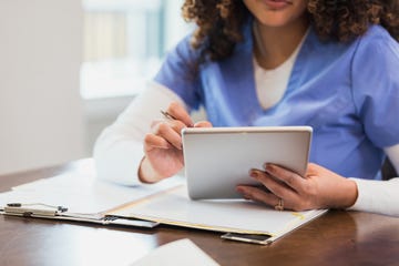 while working on a home healthcare case, a nurse uses a digital tablet add notes to a patients electronic medical chart