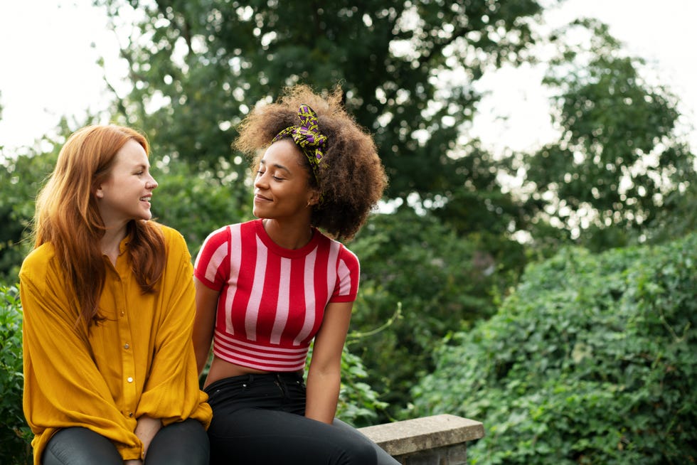 two women sat on wall