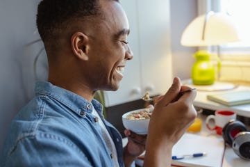 young african american man eating healthy snack at home